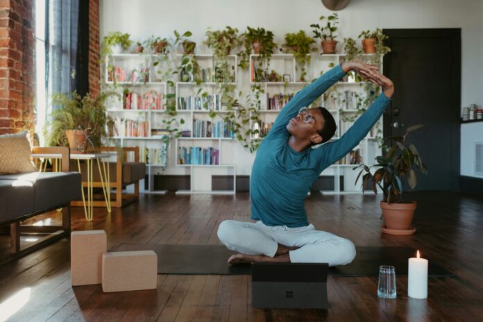 Photo by Surface a man is doing yoga in a living room