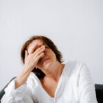 “만성피로, ‘작은 변화’가 만드는 큰 회복—최신 트렌드와 생활 루틴 팁” a woman sitting on a couch holding her hands to her face