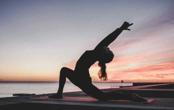 Photo by kike vega silhouette photography of woman doing yoga