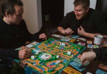 “뇌 건강 지키기, 생활 속 작은 실천에서 시작된다” two men playing a game of monopoly on a table