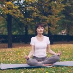 집에서도 손쉽게, ‘마음챙김 운동’ 바람… 실생활 루틴으로 스트레스 줄이기 Woman meditating in a park during autumn.
